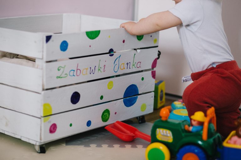 baby playing in nursery with toys